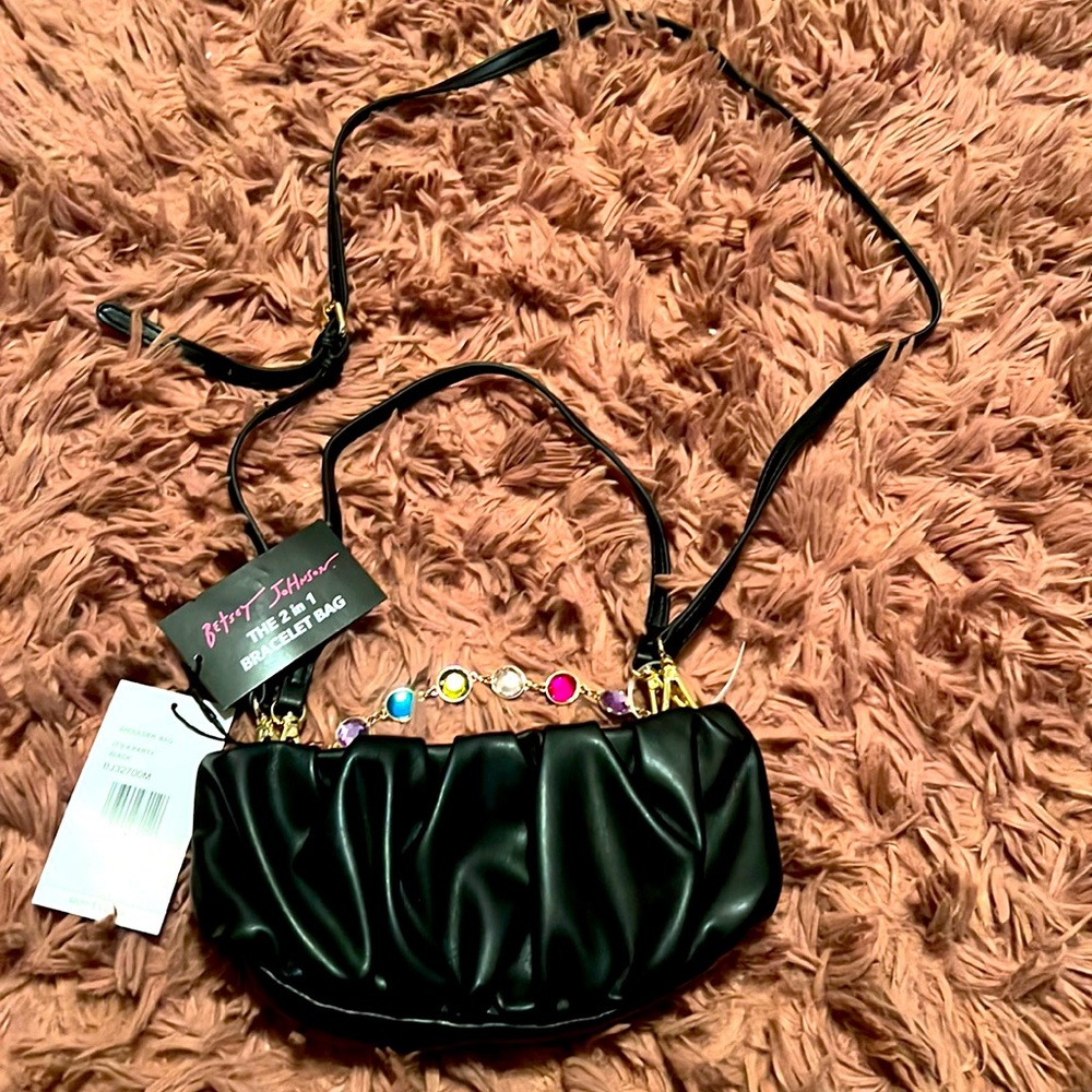 Betsey Johnson adjustable shoulder bag with handle and bracelet.